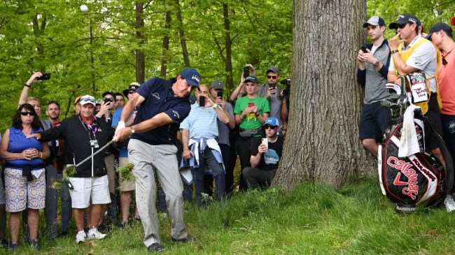 Phil Mickelson fights his way out of the rough in front of the gallery